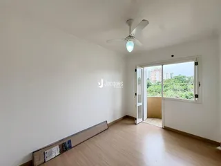 Sala de estar com piso de madeira e vista para o exterior.