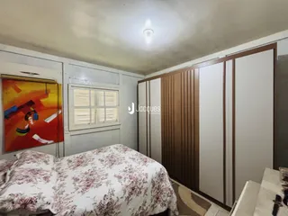 Quarto com cama e janela em ambiente interno.