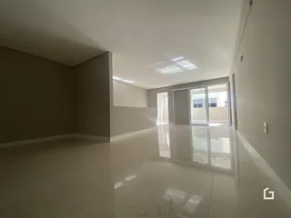 Interior de uma sala ampla com piso brilhante e paredes claras.