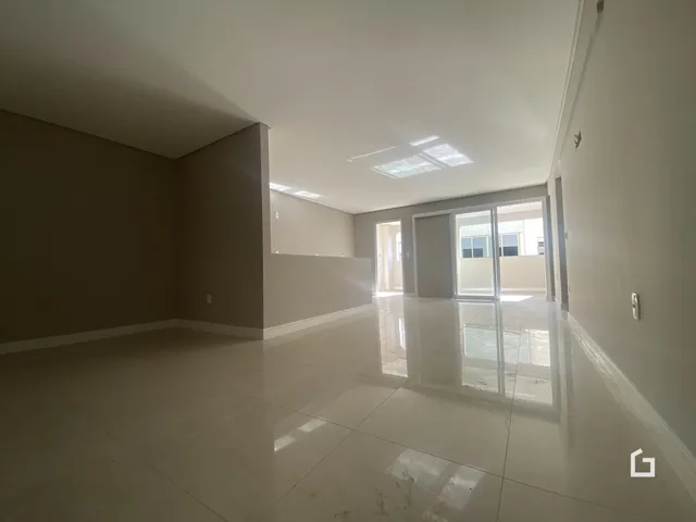 Interior de uma sala ampla com piso brilhante e paredes claras.