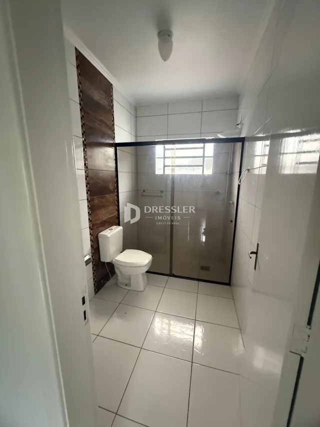 Foto de um banheiro interno com revestimento de azulejos brancos.