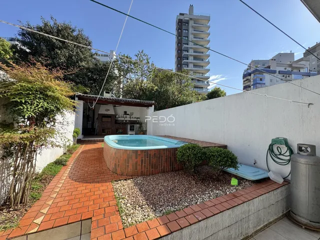 Vista externa de uma área de lazer com jacuzzi e paisagismo em Lajeado.