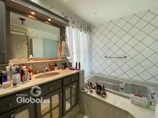 Foto de um banheiro com bancada e banheira em um imóvel no Brasil.