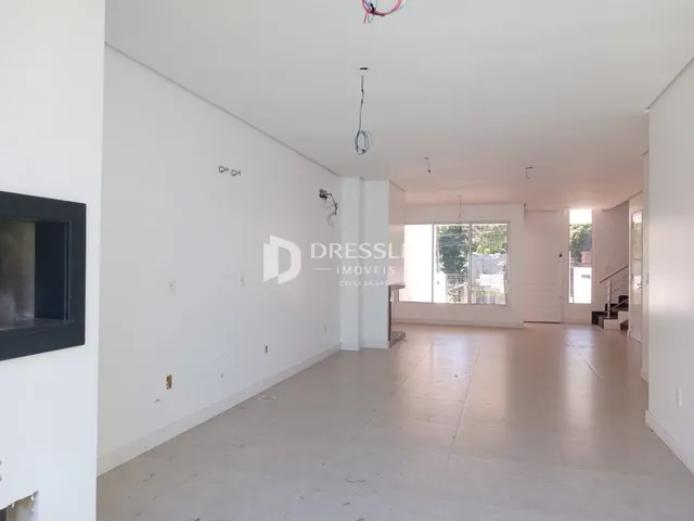 Interior de um espaço amplo com paredes brancas e piso claro.