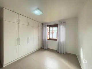 Hall de um imóvel em Lajeado, Brasil, mostrando um corredor com armários embutidos.