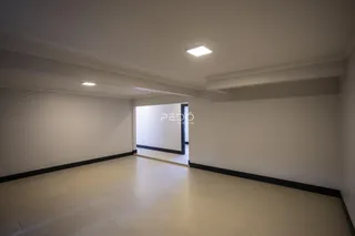 Ambiente interno de uma sala ampla e vazia.