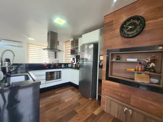 Foto de uma cozinha moderna com armários brancos e piso de madeira.