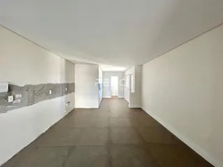 Corredor interno de uma residência com paredes brancas e piso de carpete.