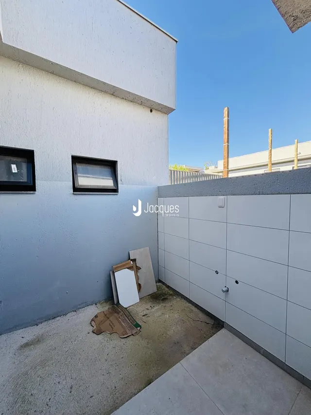 Fachada externa de uma residência em Lajeado, Brasil, com paredes azuis e uma cerca moderna.