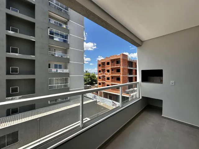 Vista de um apartamento com varanda em Lajeado, Brasil, mostrando edifícios vizinhos.