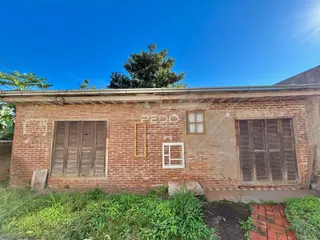 Fachada de um imóvel de tijolos com janelas de madeira em Lajeado.