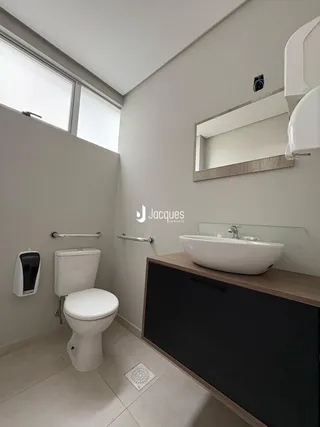 Banheiro moderno com piso claro e bancada de madeira.
