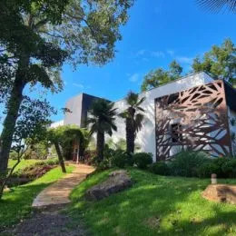 Fachada de uma residência com jardim verde.