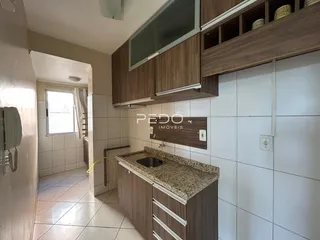Interior de um ambiente com armários de madeira e piso cerâmico.