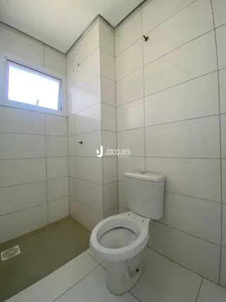 Foto de um banheiro com paredes brancas e piso claro.