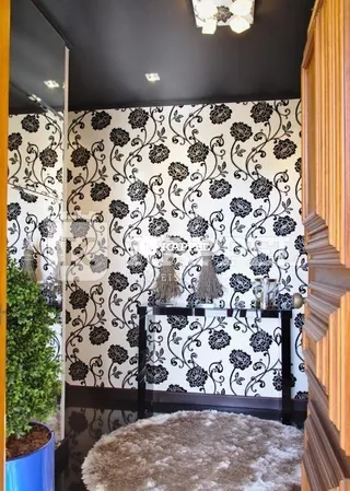 Quarto decorado com papel de parede floral preto e branco.