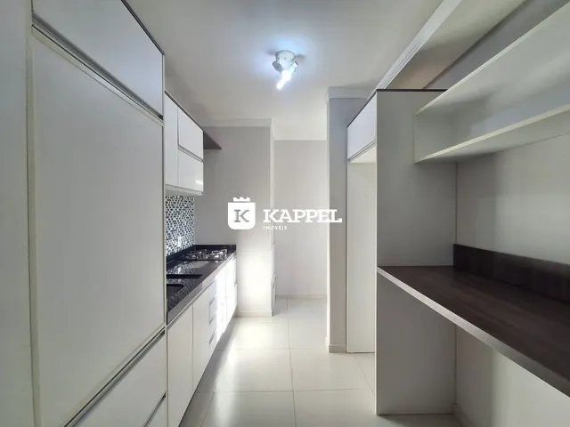 Foto de uma cozinha moderna com armários brancos e bancadas escuras.
