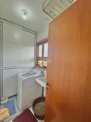 Foto de um ambiente interno mostrando uma área de serviço com máquina de lavar roupa.