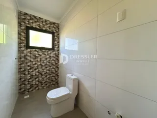 Foto de um banheiro com revestimento de parede e piso claro.
