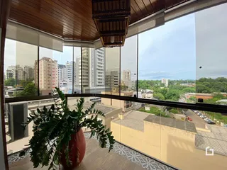 Vista da janela de um imóvel em Lajeado, Brasil, mostrando um horizonte urbano e vegetação.