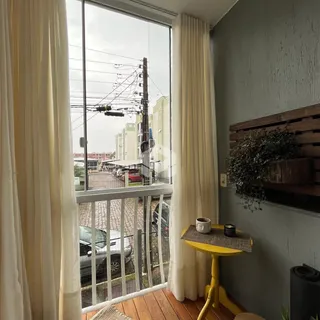 Vista da sala com grande janela de vidro e varanda em Lajeado, Brasil.