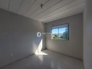 Interior de um cômodo com paredes brancas e piso de cerâmica.