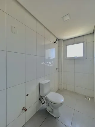 Foto de um banheiro com revestimento cerâmico branco e piso cinza claro.
