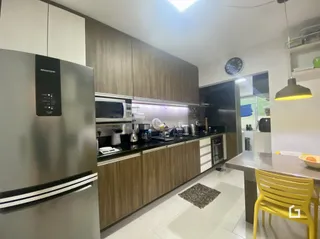 Cozinha moderna com armários de madeira e eletrodomésticos de aço inoxidável.