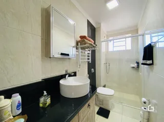 Foto de um banheiro com revestimento cerâmico e pia.