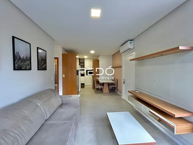 Sala de estar com sofá e painéis de madeira na residência.