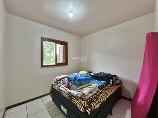 Quarto com janela e piso de cerâmica.