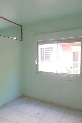 Quarto interno com paredes brancas e piso de cerâmica.