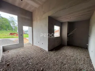 Interior de um espaço em construção com piso de cascalho.
