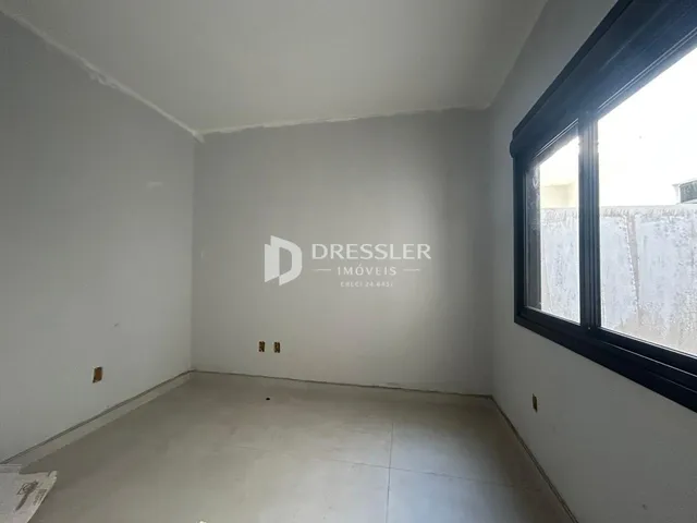 Foto de um cômodo vazio com paredes brancas e piso claro.