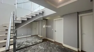 Hall de entrada com escada e paredes cinzas em uma residência.
