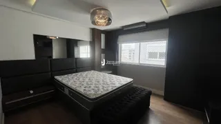 Quarto com cama grande e decoração escura.