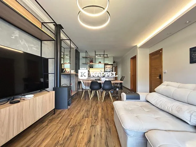 Uma sala de estar moderna com piso de madeira e área de jantar integrada.