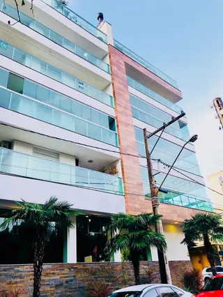 Fachada moderna de um prédio residencial com grandes janelas de vidro e área externa.