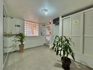 Vista interna de um ambiente claro com paredes brancas e piso de cerâmica.