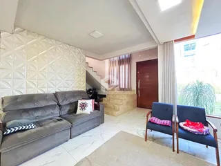 Sala de estar com sofá cinza e piso claro.