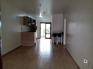 Vista de um corredor interno com piso de cerâmica e paredes brancas.
