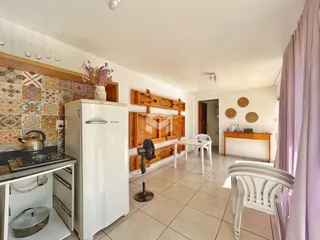 Interior de uma cozinha com revestimento cerâmico e armários de madeira.