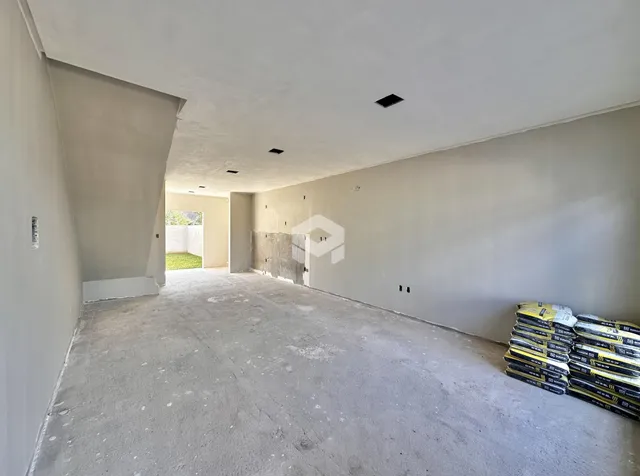 Vista interna de um espaço em concreto bruto com paredes vazadas.