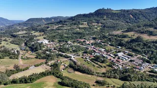 Vista aérea de uma área rural com vegetação e uma pequena comunidade em Lajeado.