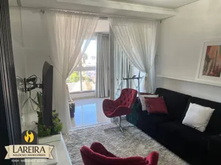 Sala de estar com sofá e poltronas vermelhas perto de uma grande janela.