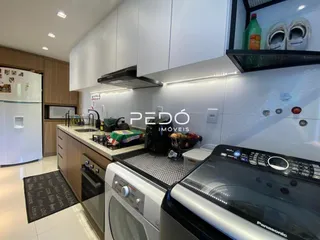 Cozinha moderna com armários brancos e eletrodomésticos de aço inoxidável.