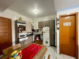 Interior de uma cozinha com armários e portas de madeira em Lajeado.