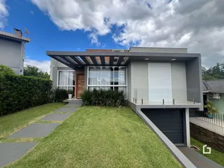 Fachada de uma casa moderna em Lajeado, Brasil com jardim e garagem.