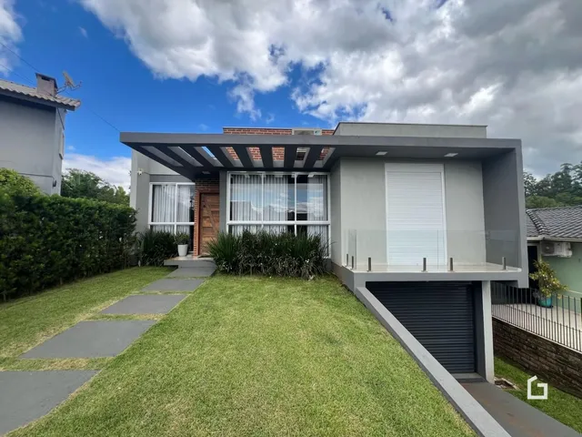 Fachada de uma casa moderna em Lajeado, Brasil com jardim e garagem.