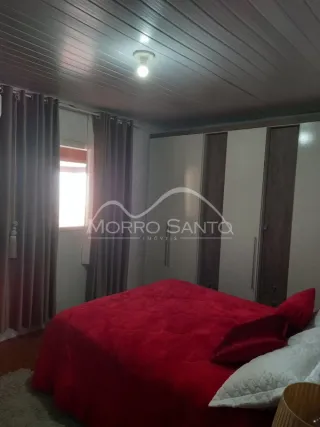Foto de um quarto mostrando uma cama com roupa de cama vermelha.